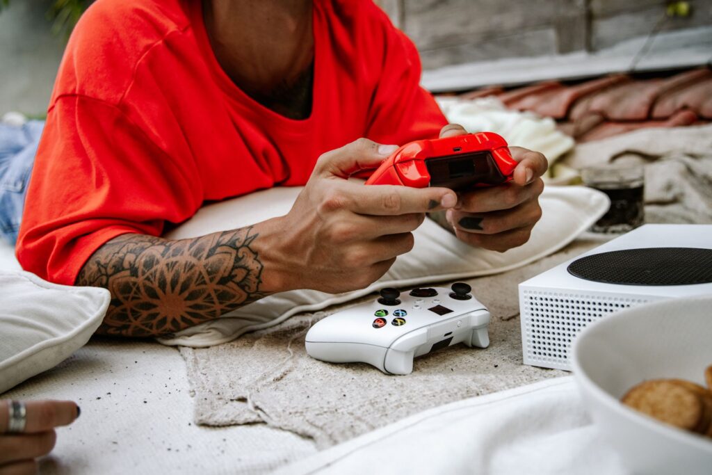 Man lying on a blanket playing video games on an XBox Series S