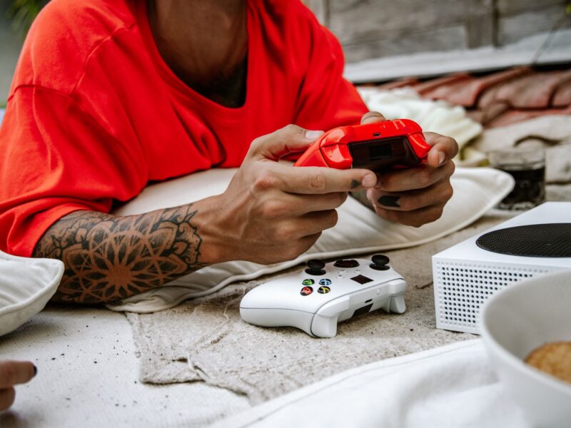 Man lying on a blanket playing video games on an XBox Series S